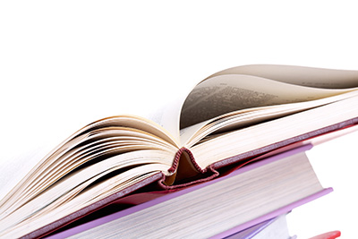 Colorful stack of textbooks with open book on its top