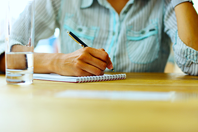 Closeup portrait of a female hand writing on a paper